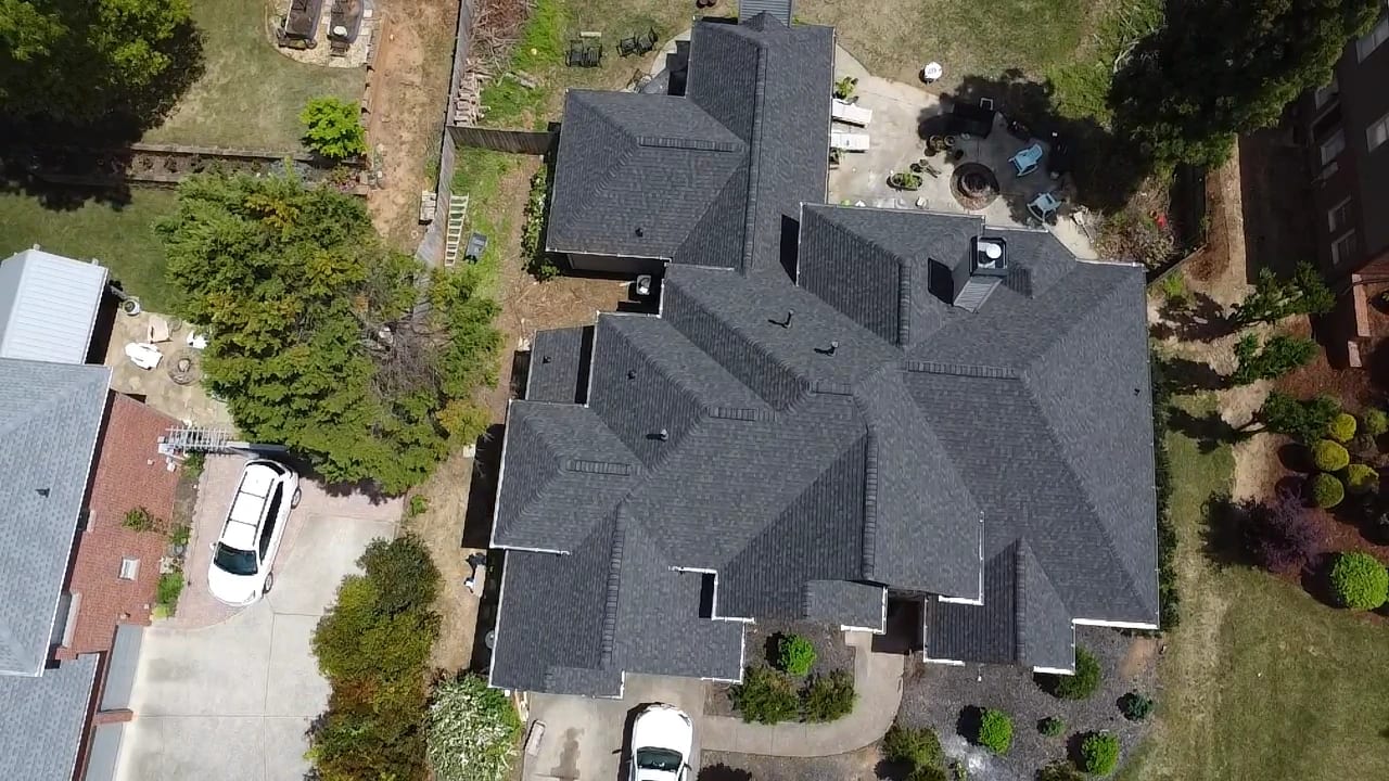 Aerial view of a completed dark gray architectural shingle roof on a large two-story home